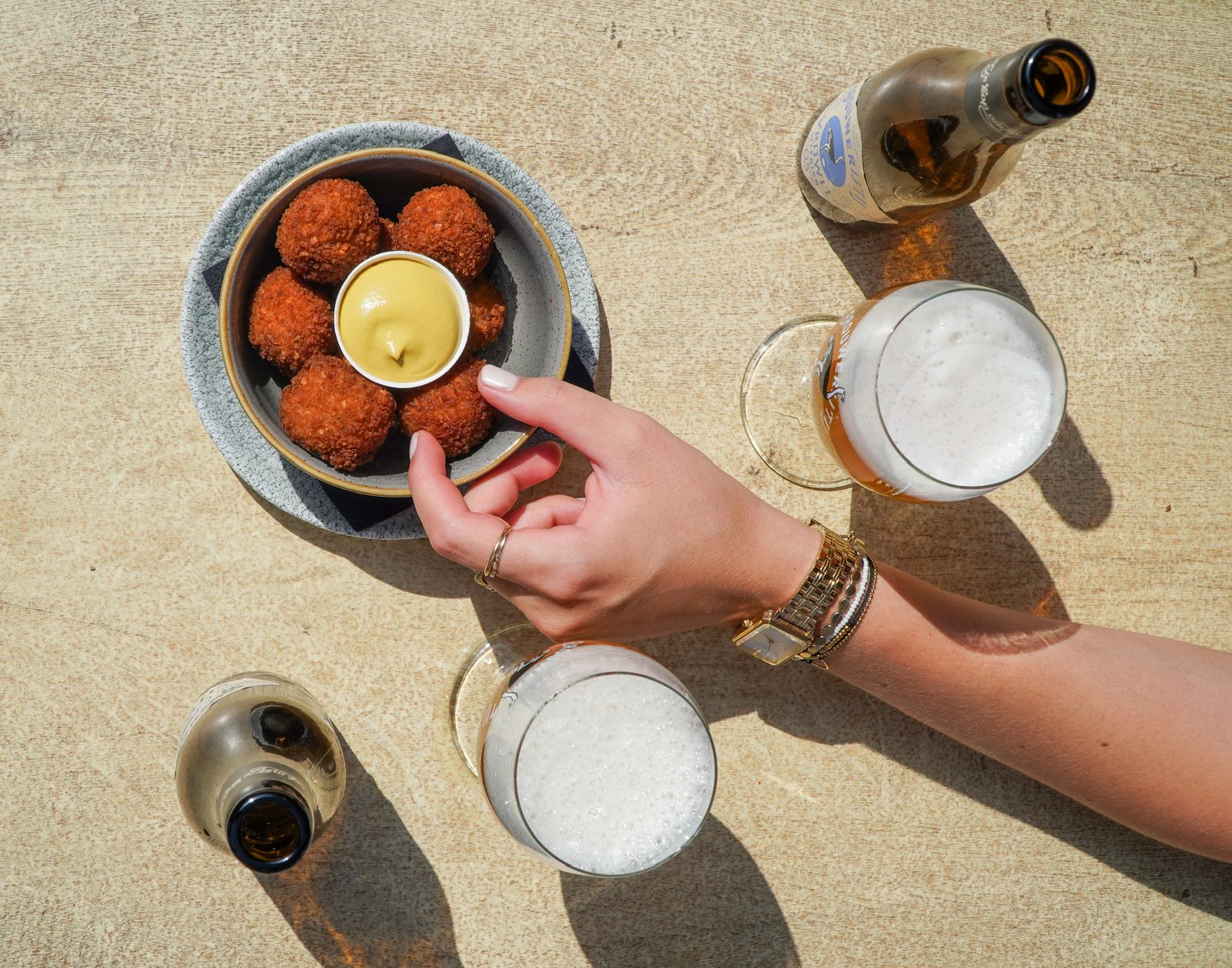 Bitterballen en bier op een terrastafel bij Gouds Glas
