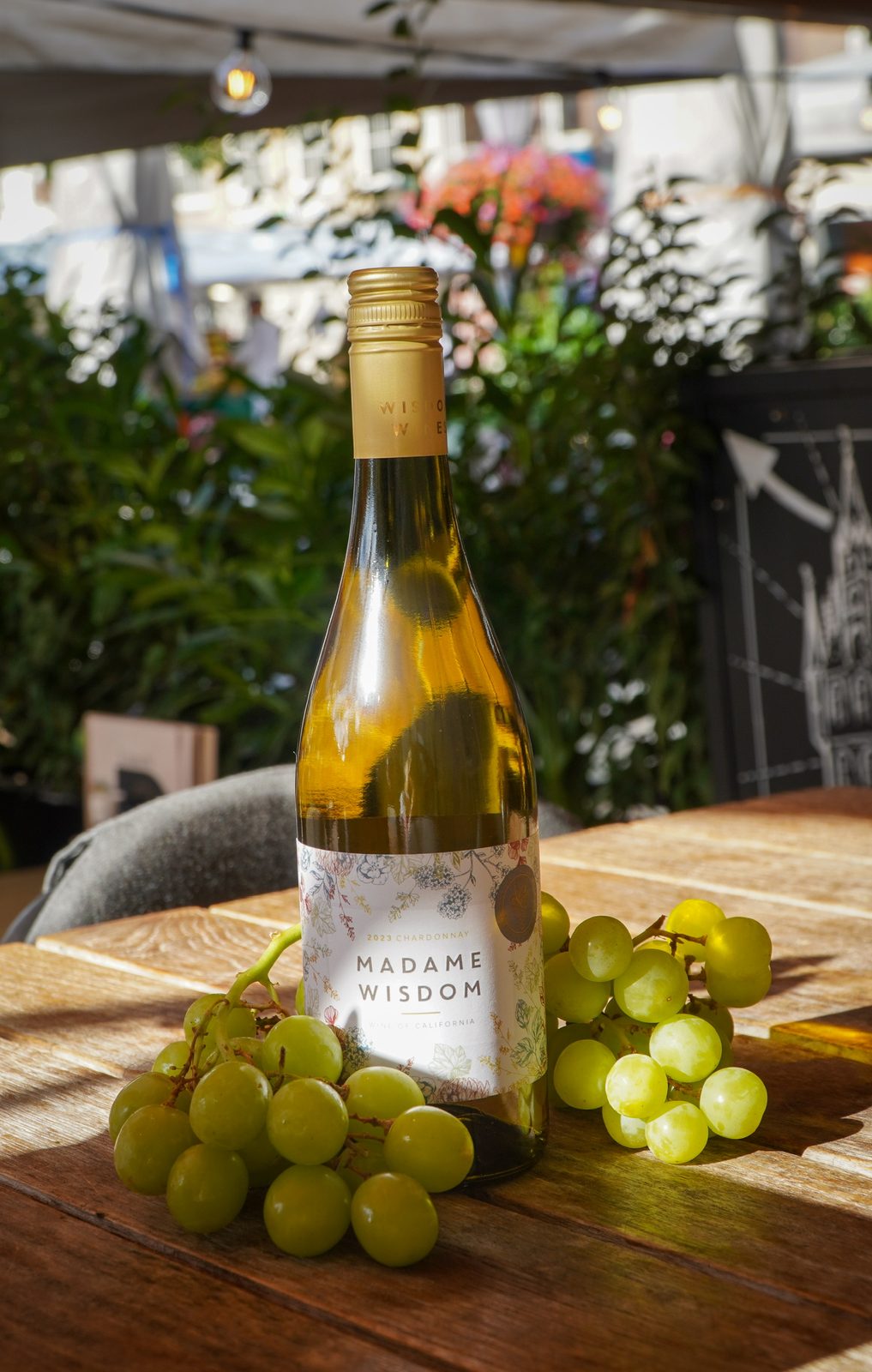 Een fles wijn met druiven op het terras van Gouds Glas